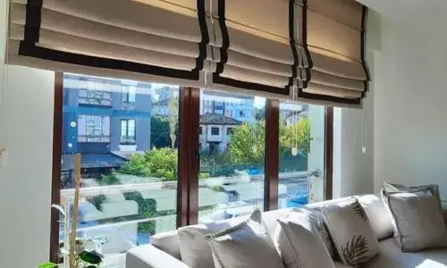 A close-up of blackout curtains installed with a wrap-around rod, effectively blocking light bleed at the edges.