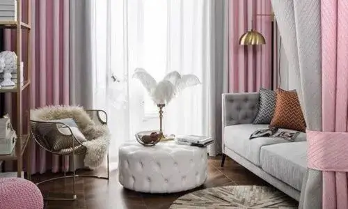 Soft blush pink curtains paired with gray furniture, creating a serene and feminine aesthetic."
